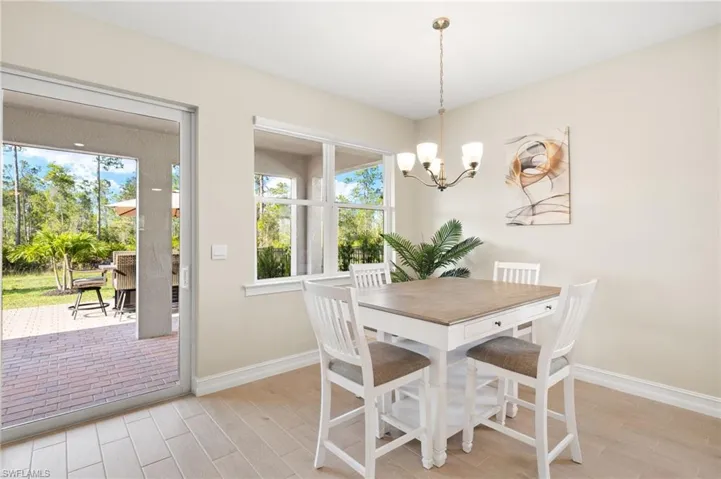 Dining space with light wood-type flooring and a chandelier
