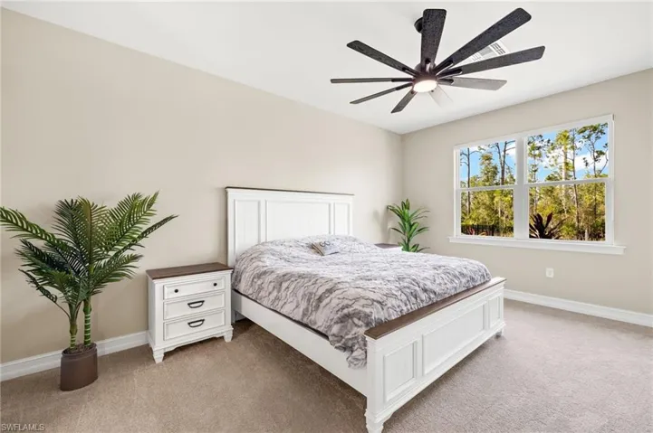Bedroom featuring light colored carpet and a ceiling fan