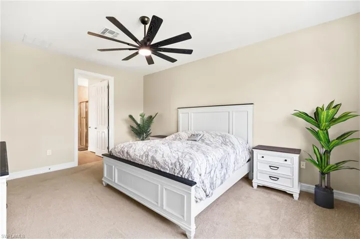 Bedroom with light carpet and a ceiling fan
