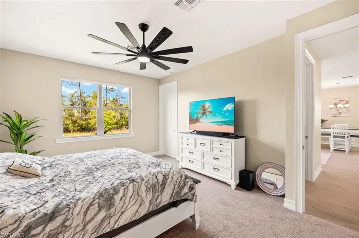 Bedroom featuring a chandelier, light carpet, and a ceiling fan