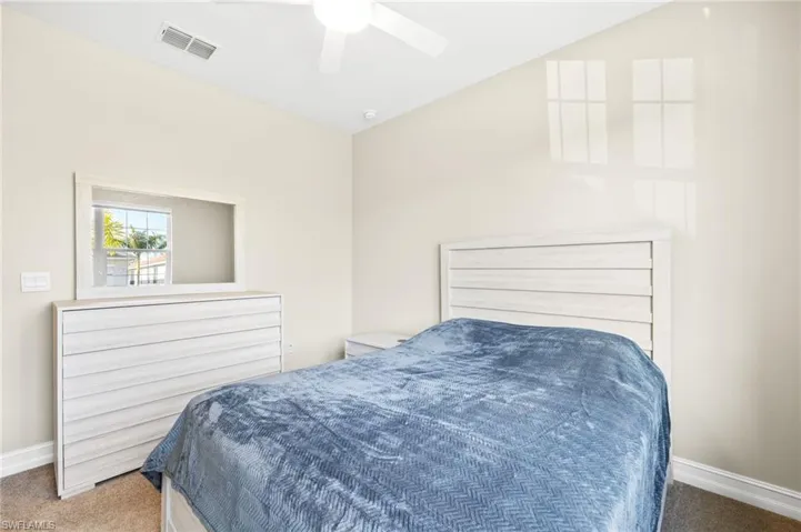 Carpeted bedroom featuring baseboards and a ceiling fan