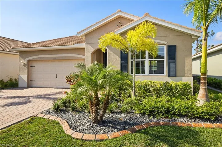 View of front of property featuring stucco siding, a garage, decorative driveway, and a tile roof