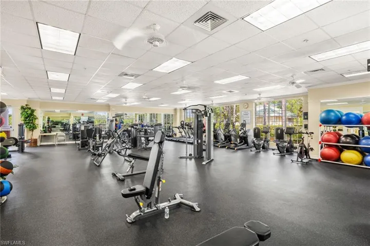 Gym with a drop ceiling and ceiling fan