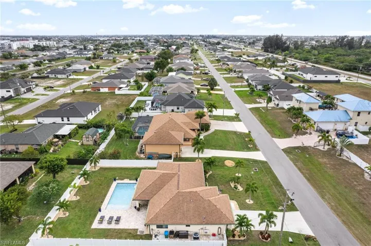 Aerial view of property and surrounding area with nearby suburban area