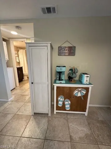 Hallway with light tile patterned floors