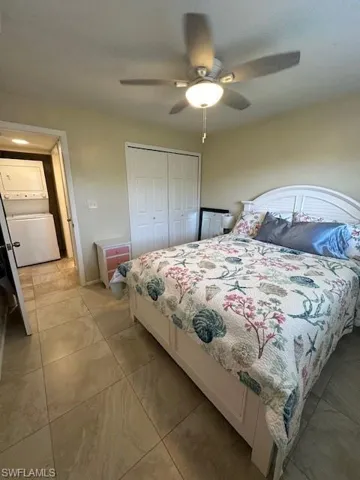 Bedroom with a closet, ceiling fan, light tile patterned floors