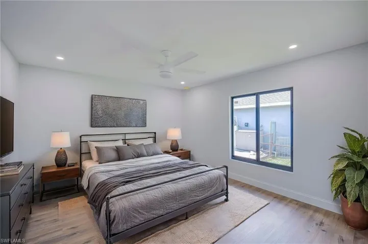 Room featuring wood-finish flooring, recessed lighting, a white ceiling fan, and a dual-pane window