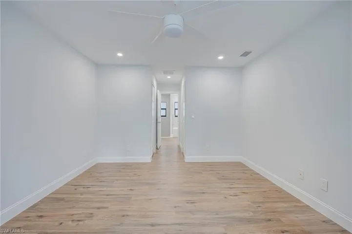 Interior space featuring wood-finish flooring, a neutral color palette, recessed lighting, and a ceiling fan