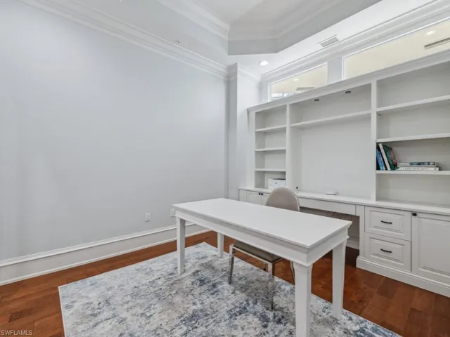 Office area with ornamental molding and dark wood-type flooring