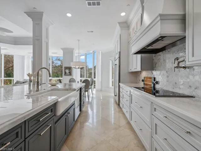 Kitchen featuring black electric stovetop, white cabinetry, and a healthy amount of sunlight