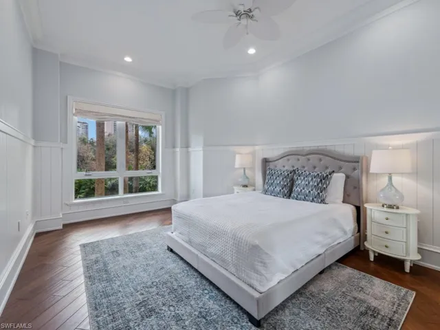 Bedroom featuring ceiling fan, ornamental molding, and dark wood-type flooring