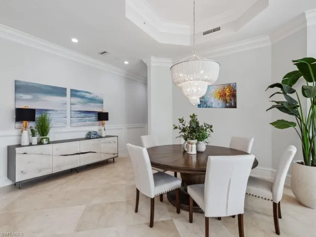 Dining room featuring a chandelier, a tray ceiling, and crown molding