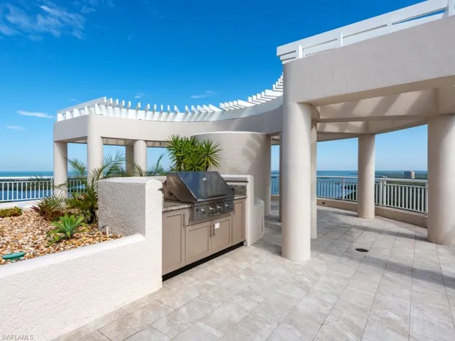View of patio / terrace featuring a grill, a water view, and exterior kitchen