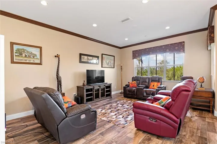 Living area with wood finished floors, recessed lighting, and ornamental molding