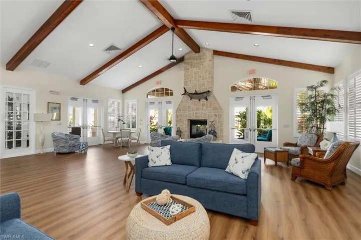 Living room with french doors, high vaulted ceiling, healthy amount of natural light, wood finished floors, and recessed lighting