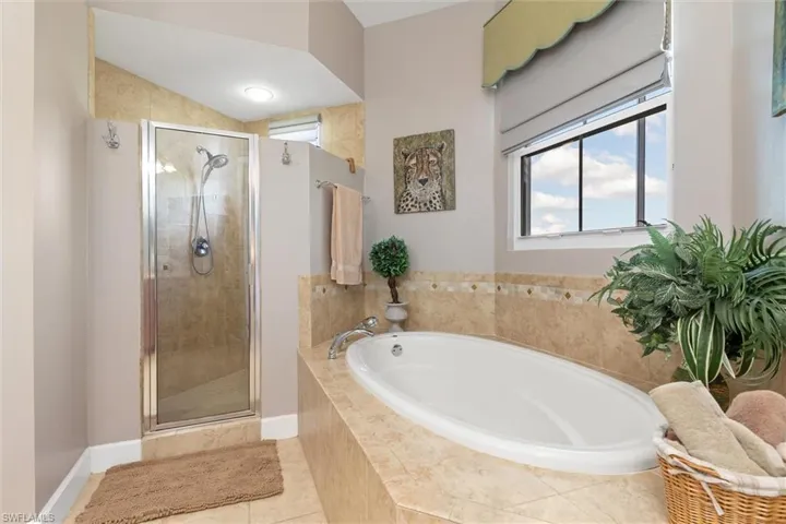 Full bathroom with a garden tub, a stall shower, plenty of natural light, and light tile patterned floors