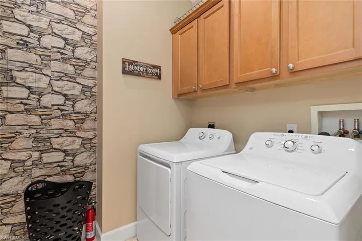 Laundry area with independent washer and dryer and cabinet space