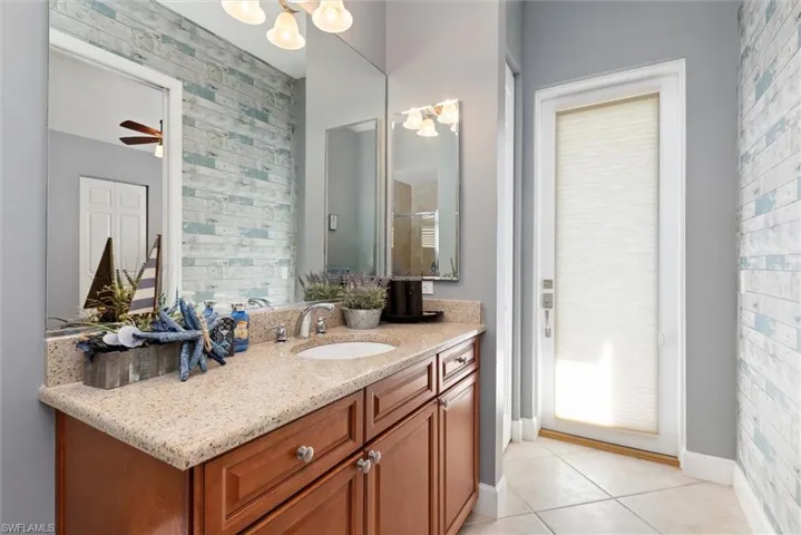 Full bath with vanity, light tile patterned floors, a chandelier, and a stall shower
