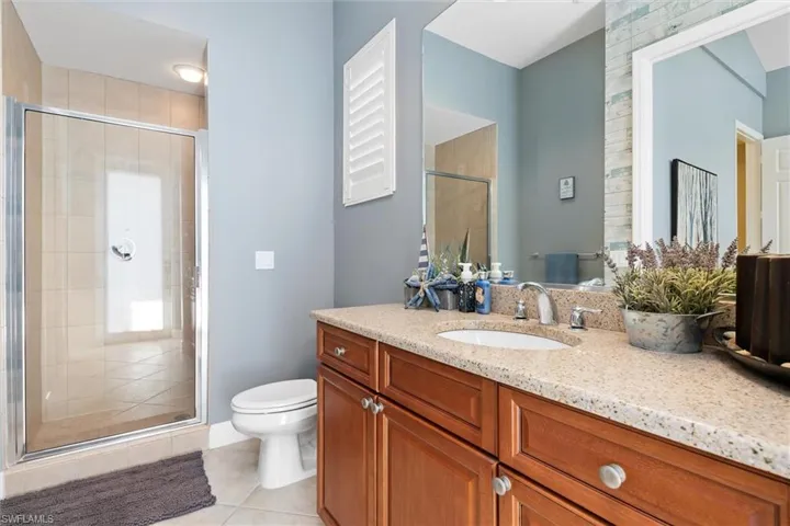 Full bathroom featuring vanity, a shower stall, and light tile patterned floors