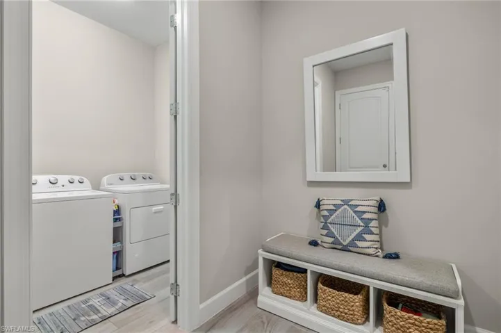 Clothes washing area featuring separate washer and dryer and light hardwood / wood-style floors