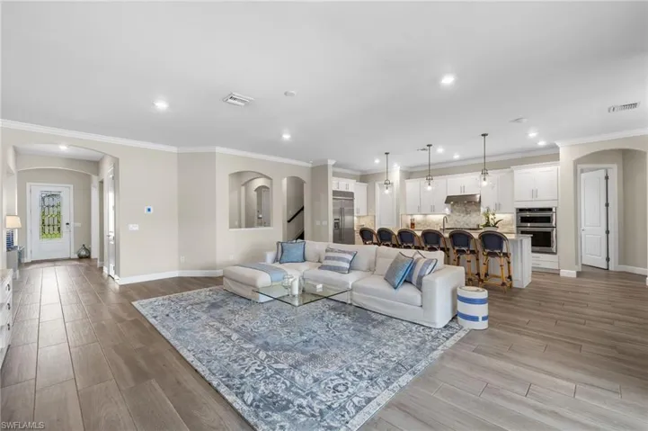 Living room featuring ornamental molding and light hardwood / wood-style floors