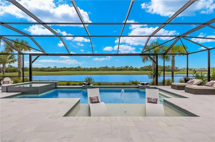 View of pool with a water view, pool water feature, an in ground hot tub, a patio, and a lanai