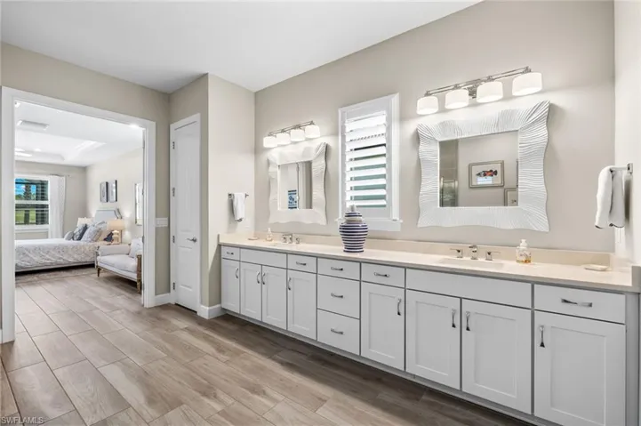 Bathroom featuring a raised ceiling, hardwood / wood-style flooring, and double sink vanity