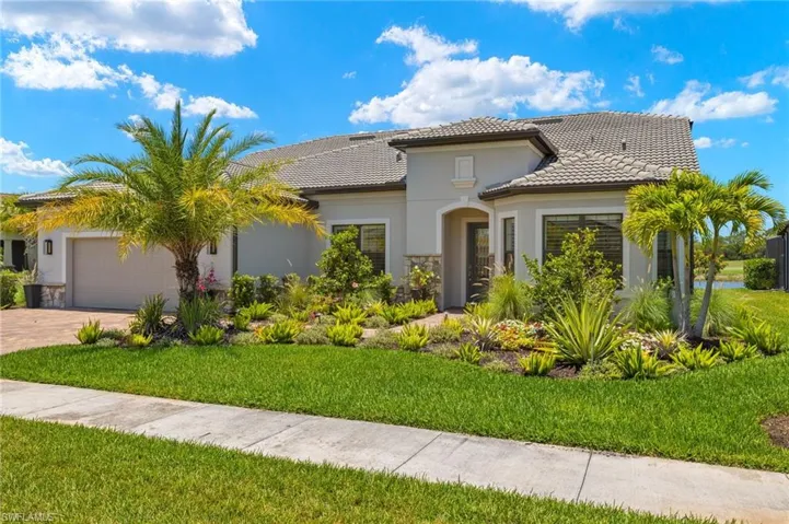 Mediterranean / spanish house with a garage and a front lawn