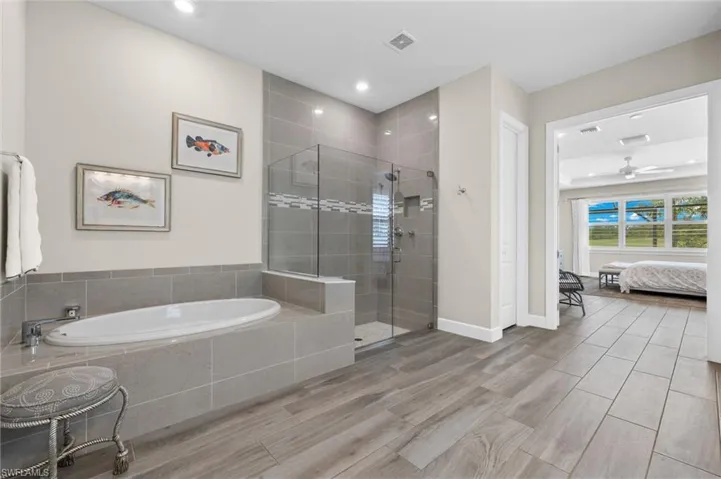 Bathroom featuring ceiling fan and separate shower and tub