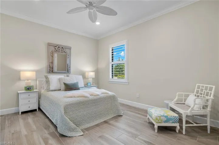 Bedroom with ceiling fan, crown molding, and light hardwood / wood-style flooring