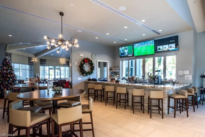 Tiled dining space with a healthy amount of sunlight, a towering ceiling, and a chandelier