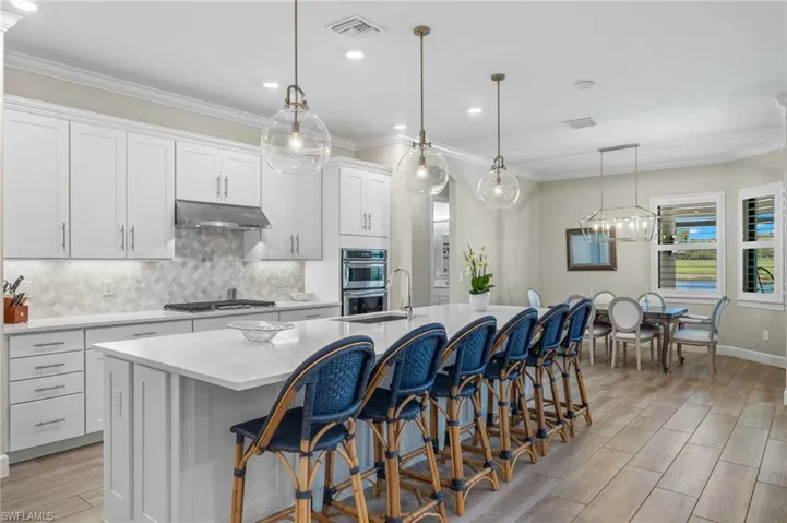 Kitchen featuring hanging light fixtures, an island with sink, and appliances with stainless steel finishes