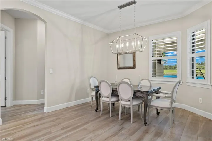 Dining space featuring a notable chandelier, light hardwood / wood-style floors, and crown molding