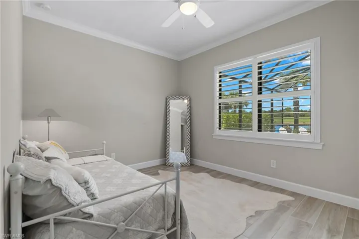 Bedroom with ceiling fan, crown molding, and hardwood / wood-style flooring