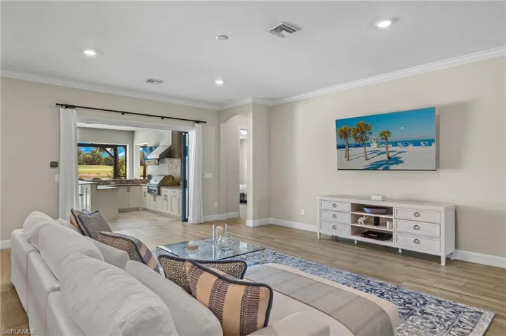 Living room featuring ornamental molding and light hardwood / wood-style floors