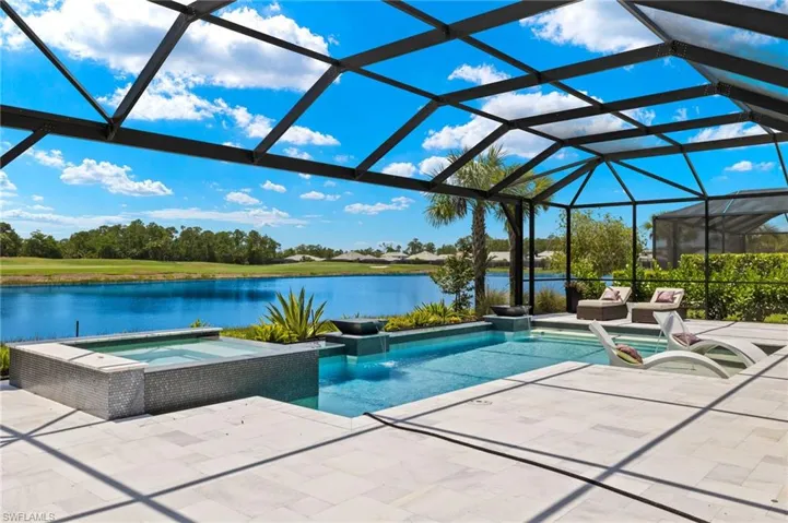 View of swimming pool featuring glass enclosure, an in ground hot tub, and a patio