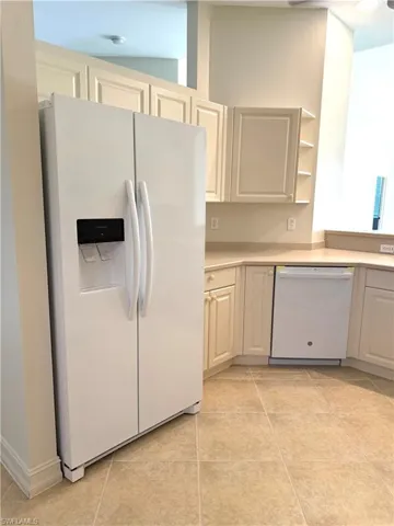 Kitchen featuring white appliances, light countertops, open shelves, and light tile patterned flooring