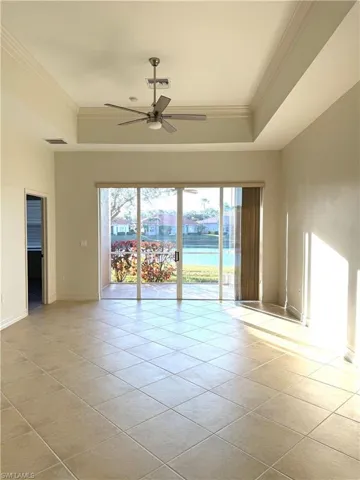Spare room with ceiling fan, light tile patterned flooring, ornamental molding, and a water view