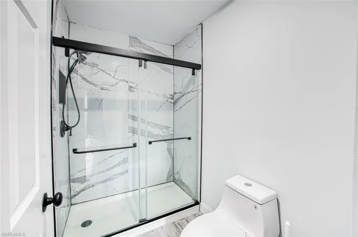 Bathroom featuring toilet and an enclosed shower