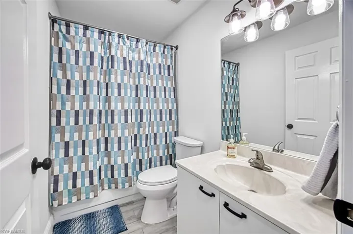Bathroom featuring hardwood / wood-style floors, vanity, and toilet