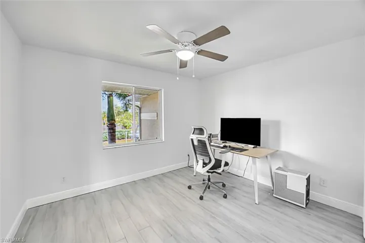 Office area with light wood-type flooring and ceiling fan