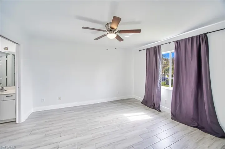 Unfurnished room with ceiling fan and light hardwood / wood-style floors