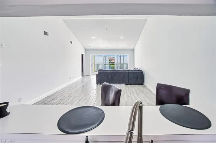 Dining area with light hardwood / wood-style floors and lofted ceiling