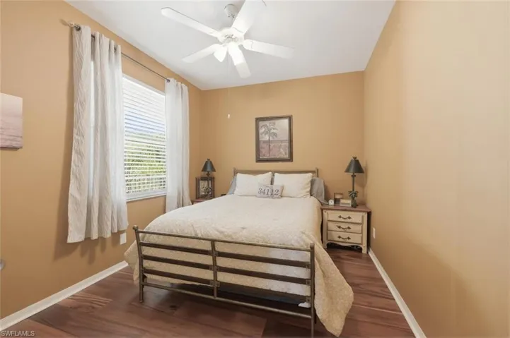 Bedroom with dark wood-type flooring and a ceiling fan