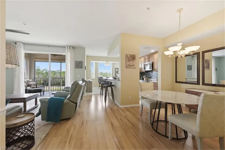 Dining space with light wood-style floors and suspended lighting
