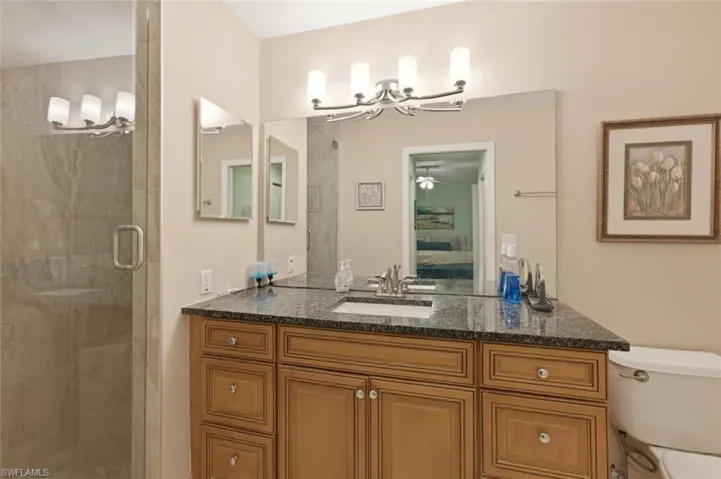 Full bath featuring vanity, a stall shower, and ensuite bath