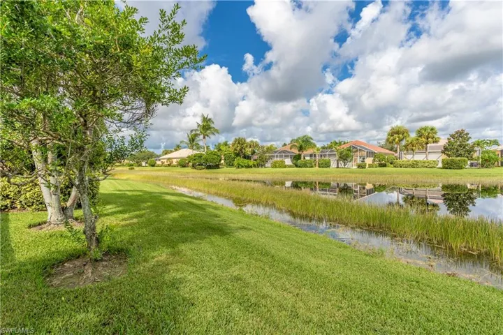 View of property's community with a water view and a lawn