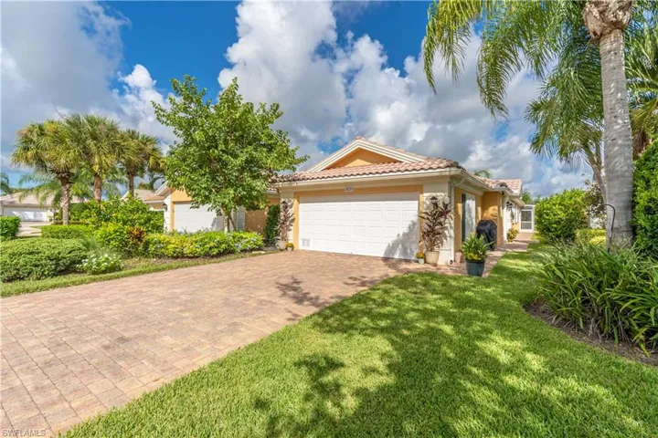 Mediterranean / spanish home featuring a front yard and a garage