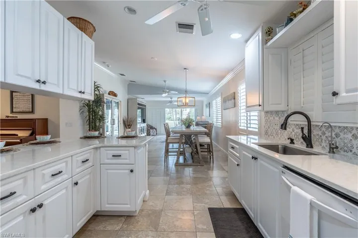 Kitchen with crown molding, dishwasher, kitchen peninsula, sink, and ceiling fan