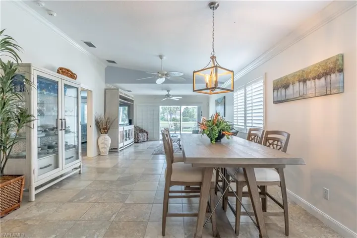 Dining space featuring ceiling fan with notable chandelier and ornamental molding